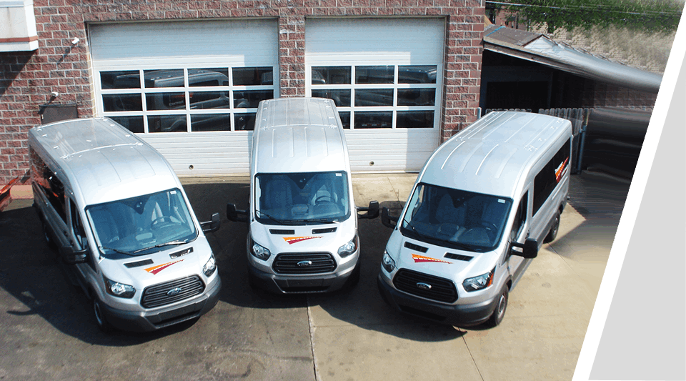 Three vans parked in a lot next to each other.